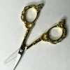 Ciseaux de précision 11 cm vintage motif floral posés sur tissu, prêts pour couture et broderie